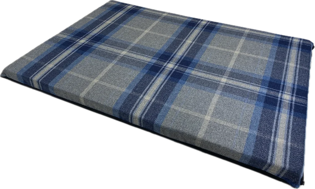 A rectangular plaid cushion or pad in blue, gray, and white tones, shown at an angle on a plain white background.